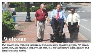 Image of two men walking and one in wheelchair on sidewalk